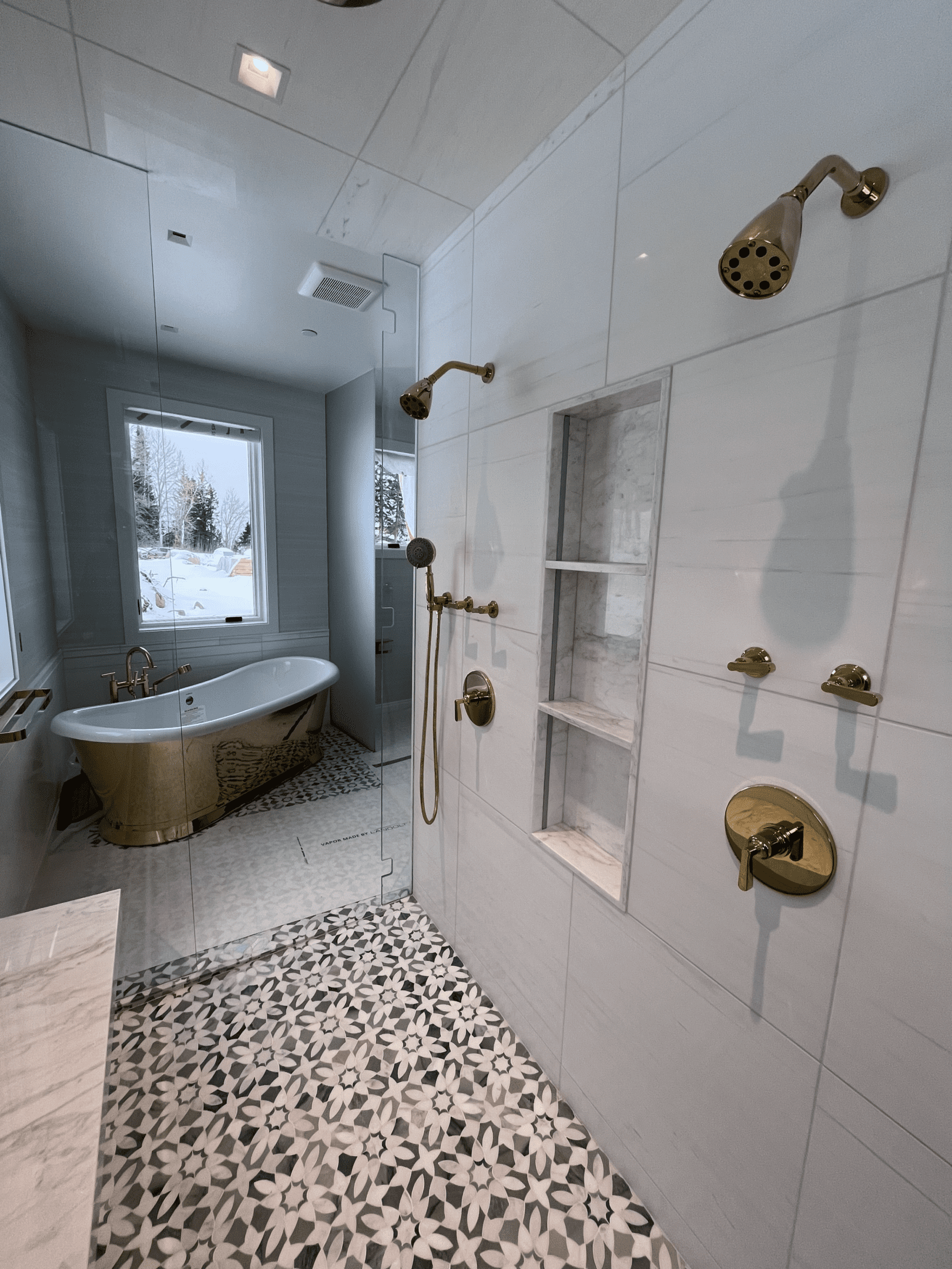 Elegant bathroom with gold fixtures and a freestanding tub.
