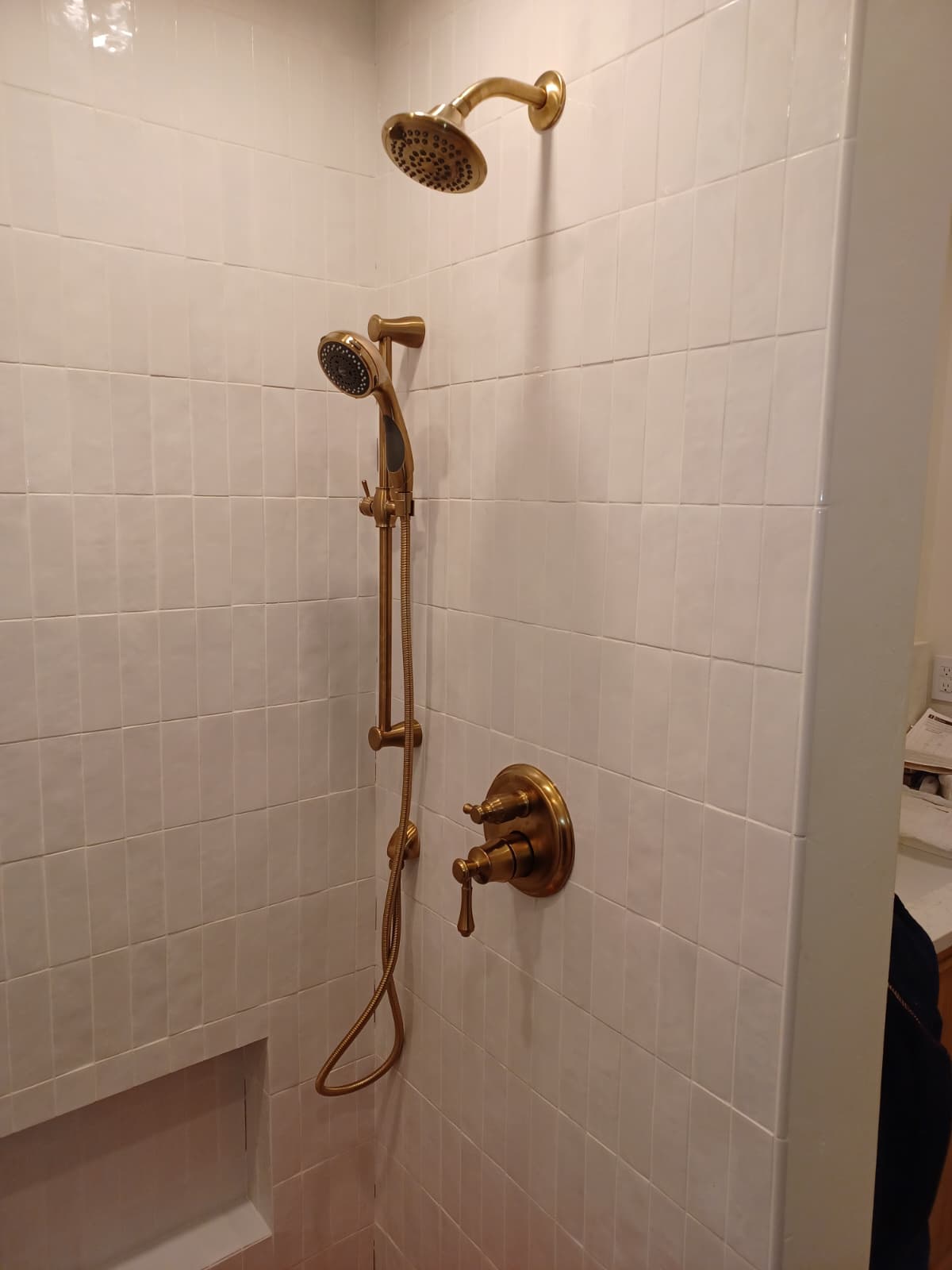 Vintage-style shower with gold fixtures and handheld showerhead.