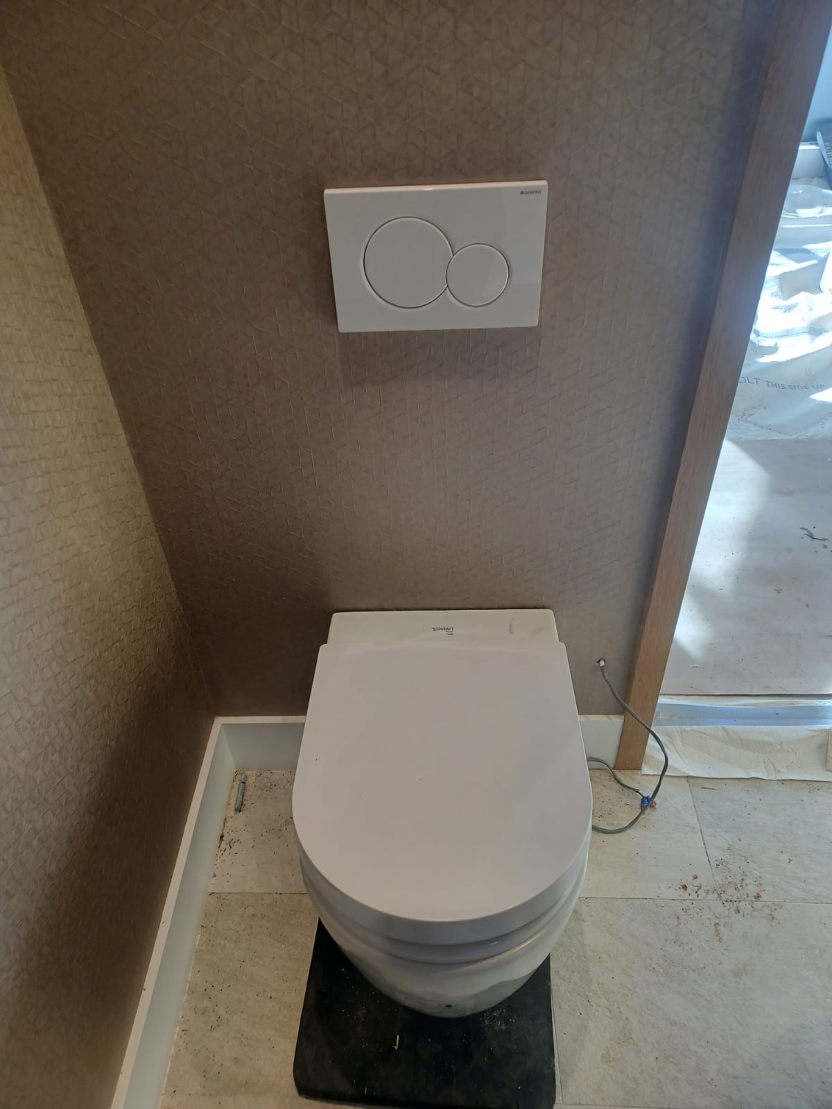Modern toilet with dual flush buttons and a closed lid.