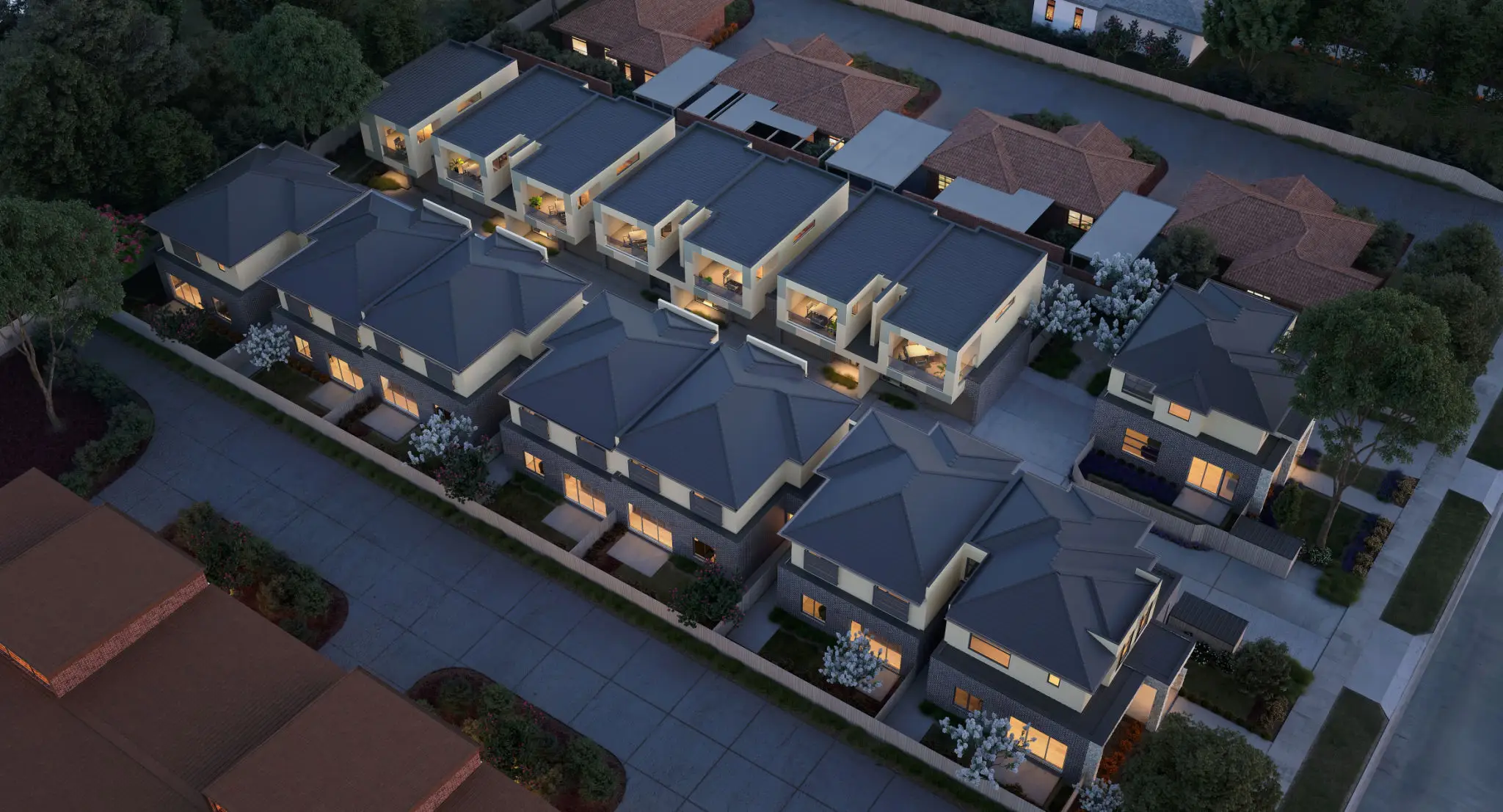 Aerial view of modern townhouses with gray roofs and outdoor patios.
